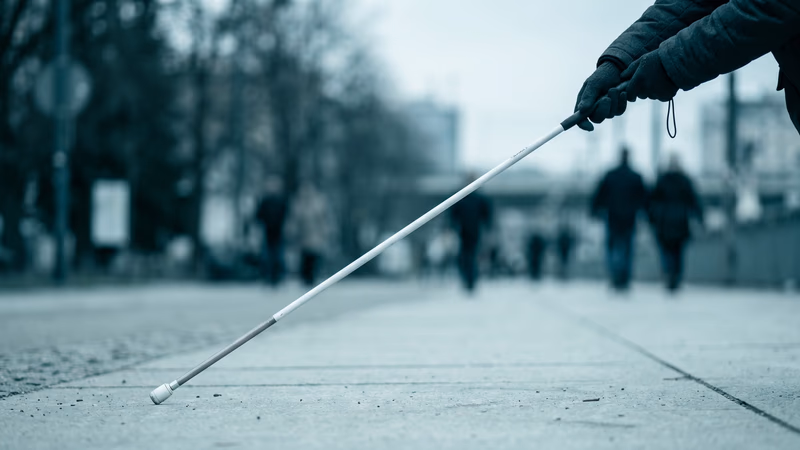 Close-up of hands using a white cane on a smooth pale pavement surface, representing web accessibility and inclusive design principles covered in WCAG guidelines