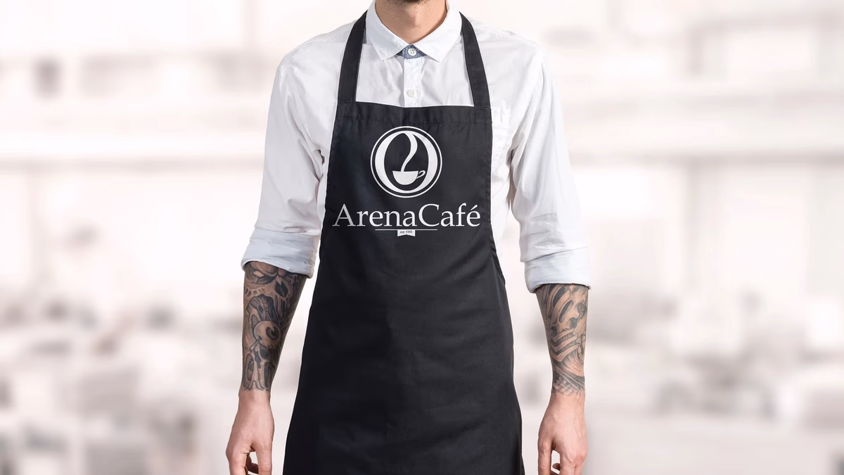 Arena Cafe branded apron worn by staff, showing the logo and identity system designed by Desque