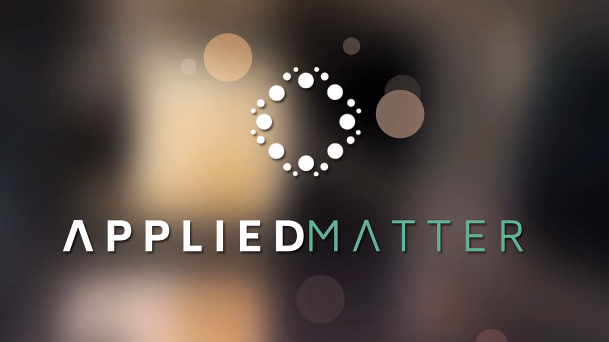 Applied Matter brand identity designed by Desque, reverse logo on atmospheric dark business card