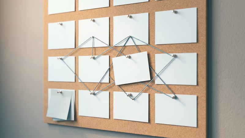A cork pinboard with a grid of blank index cards connected by muted teal string, representing a structured content planning framework and editorial calendar
