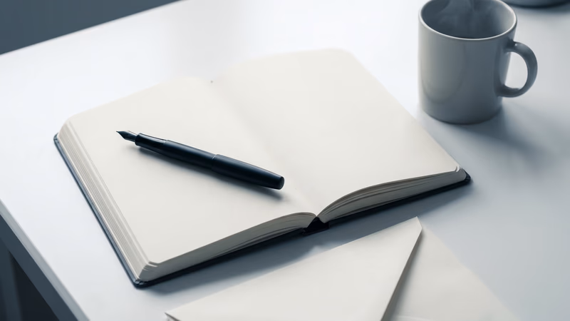 A blank open notebook, fountain pen, and ceramic coffee mug on a clean white writing desk in soft natural light, representing the craft of writing engaging blog posts