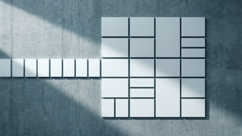 Overhead flat-lay of blank modular rectangular panels arranged in a precise two-dimensional grid on concrete, illustrating CSS Grid two-axis and Flexbox one-axis layout structure