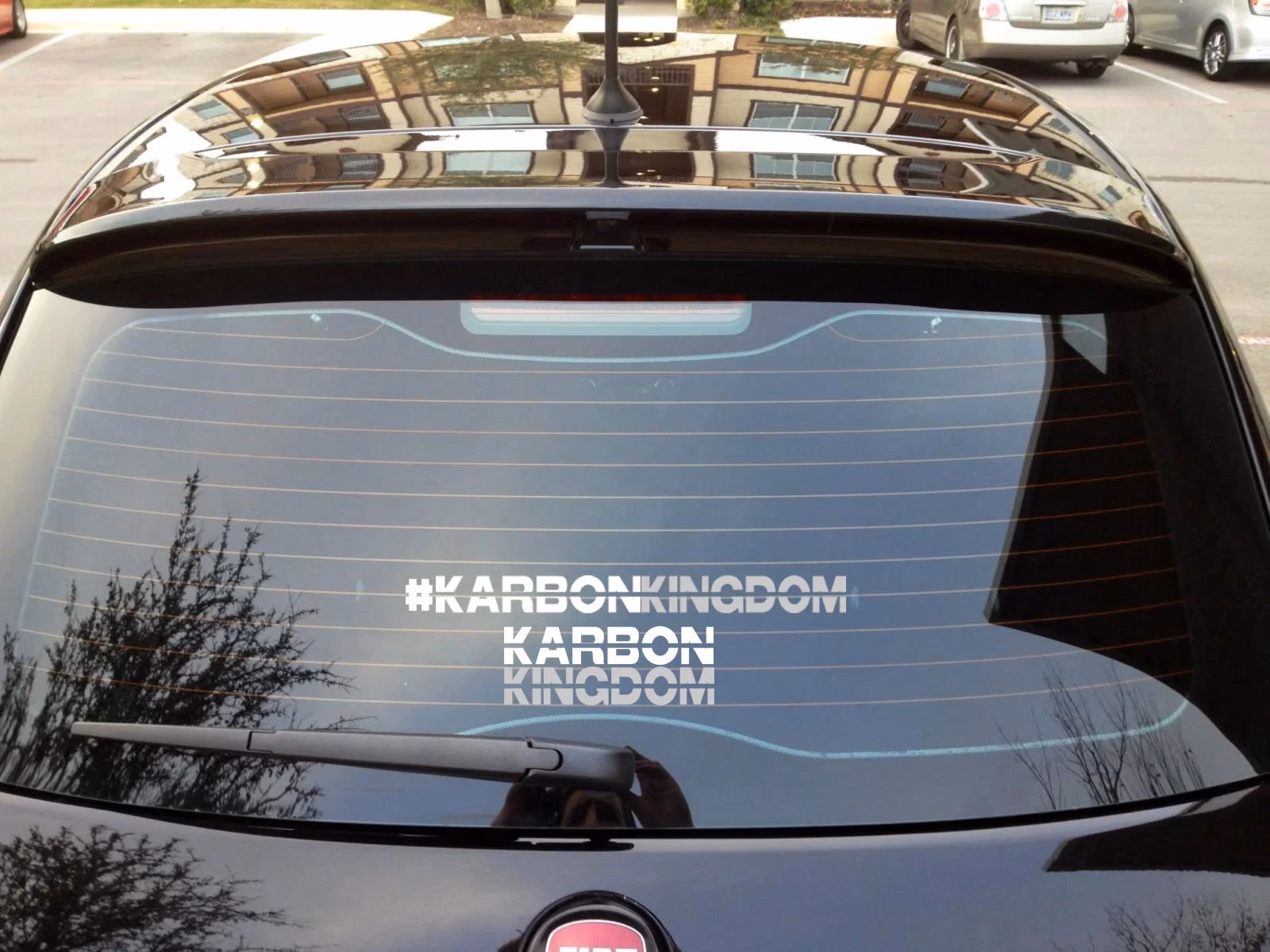 Karbon Kingdom stacked decal applied to dark vehicle rear window, designed by Desque