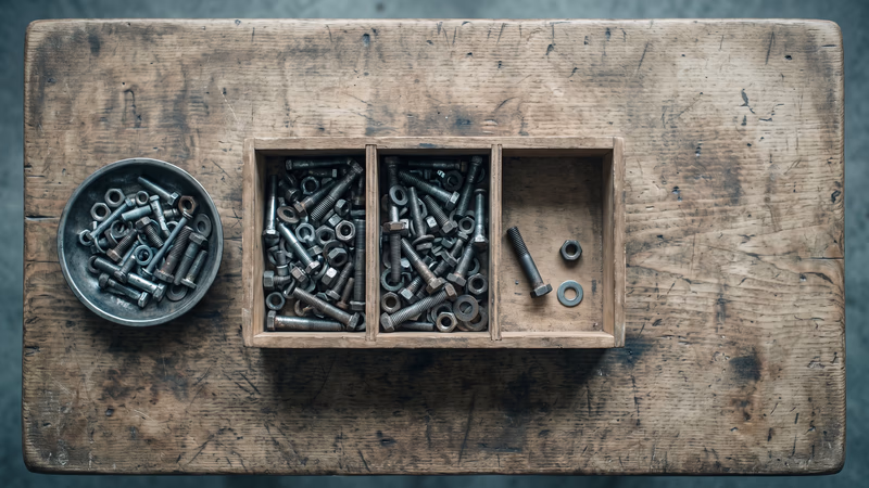 An overhead view of a three-compartment wooden parts organizer on a workbench, two compartments crowded with mismatched hardware and one nearly empty, the three-pile plugin audit before a WordPress to Webflow migration