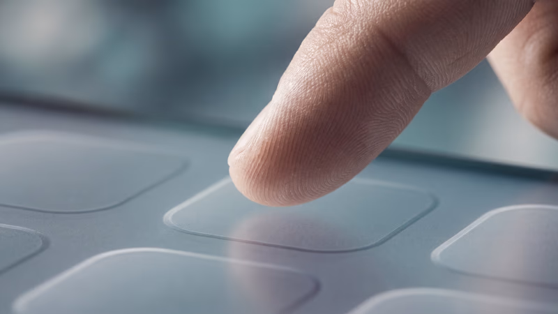 A single fingertip touching a blank touchscreen with abstract geometric tap-target shapes in relief, representing touch-friendly mobile interface design principles