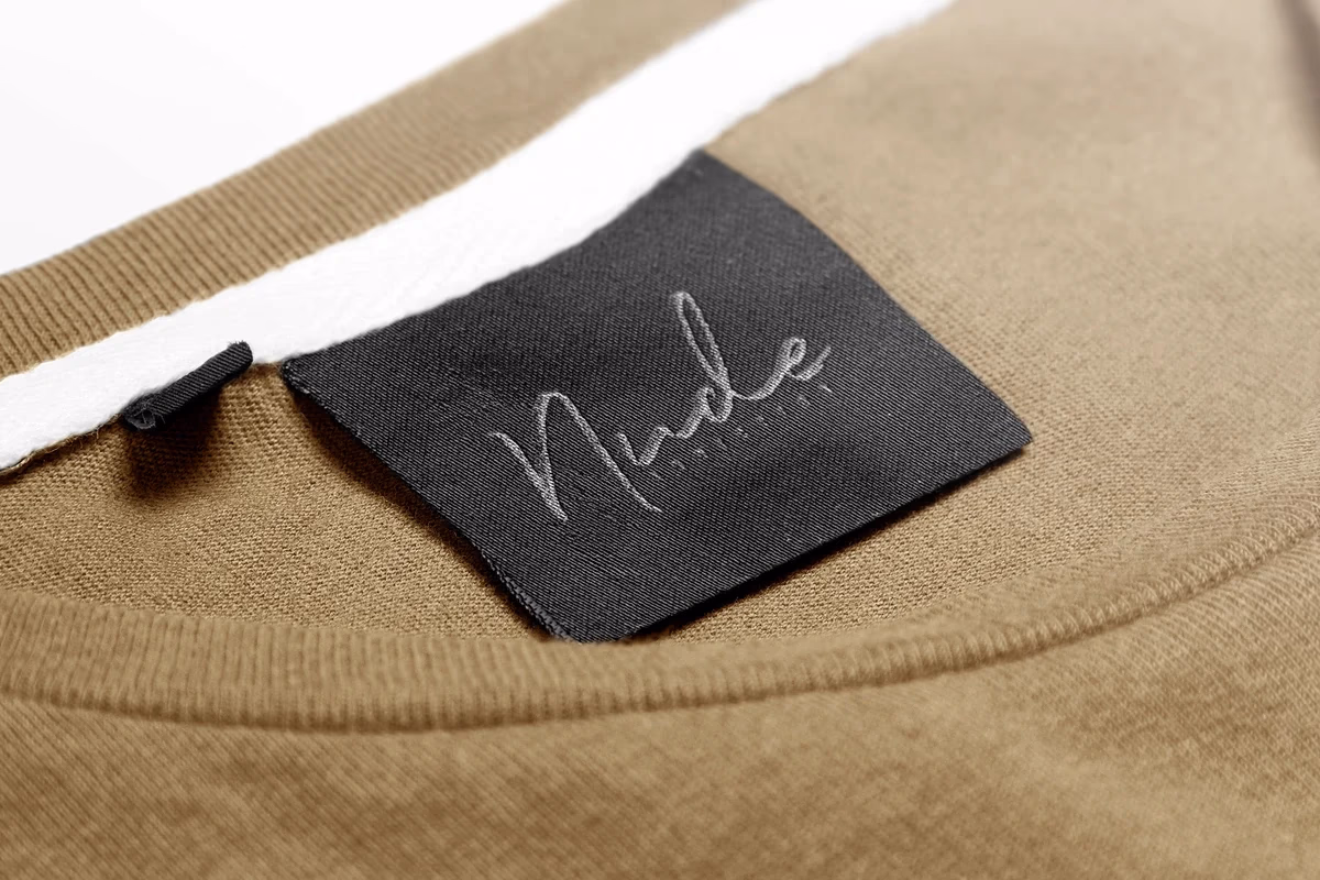 Nude Addiction shirt tag mockup designed by Desque showing logo mark on apparel hang tag