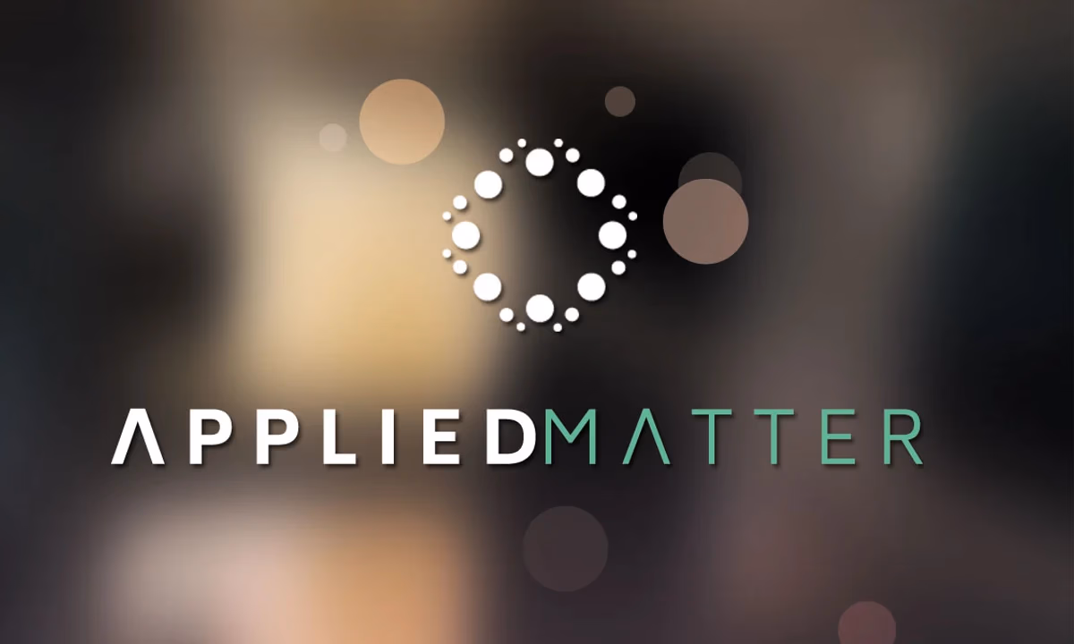 Applied Matter business card front with reverse logo on dark atmospheric background designed by Desque