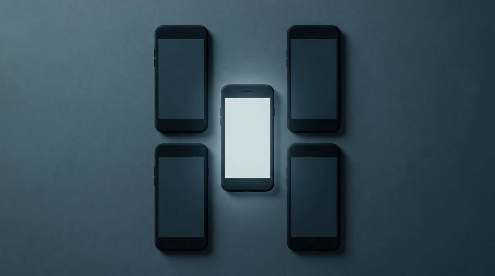 Grid of blank smartphone screens on a dark surface with one screen illuminated, representing the strategic selection of a single social media platform for business